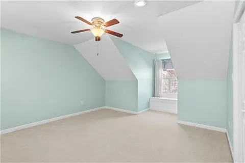 an empty room with a chandelier fan and windows