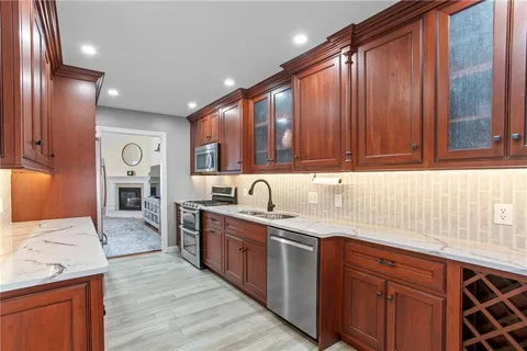 a kitchen with stainless steel appliances granite countertop wooden cabinets a sink and dishwasher