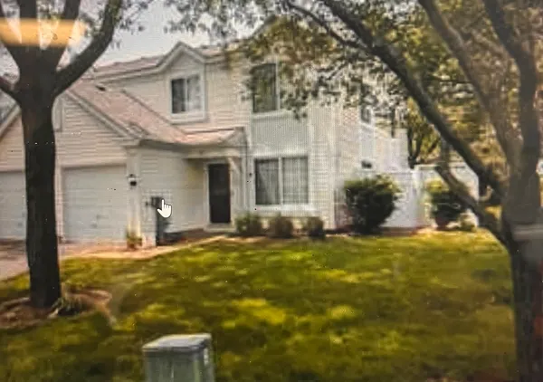 a view of a white house with a large tree