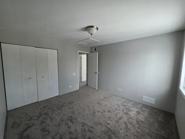 a view of an empty room and chandelier fan