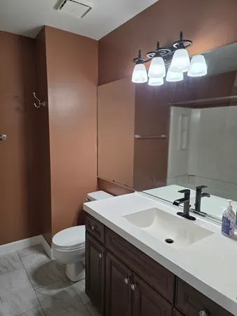 a bathroom with a sink vanity mirror and toilet