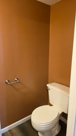 a white toilet sitting next to a white wall