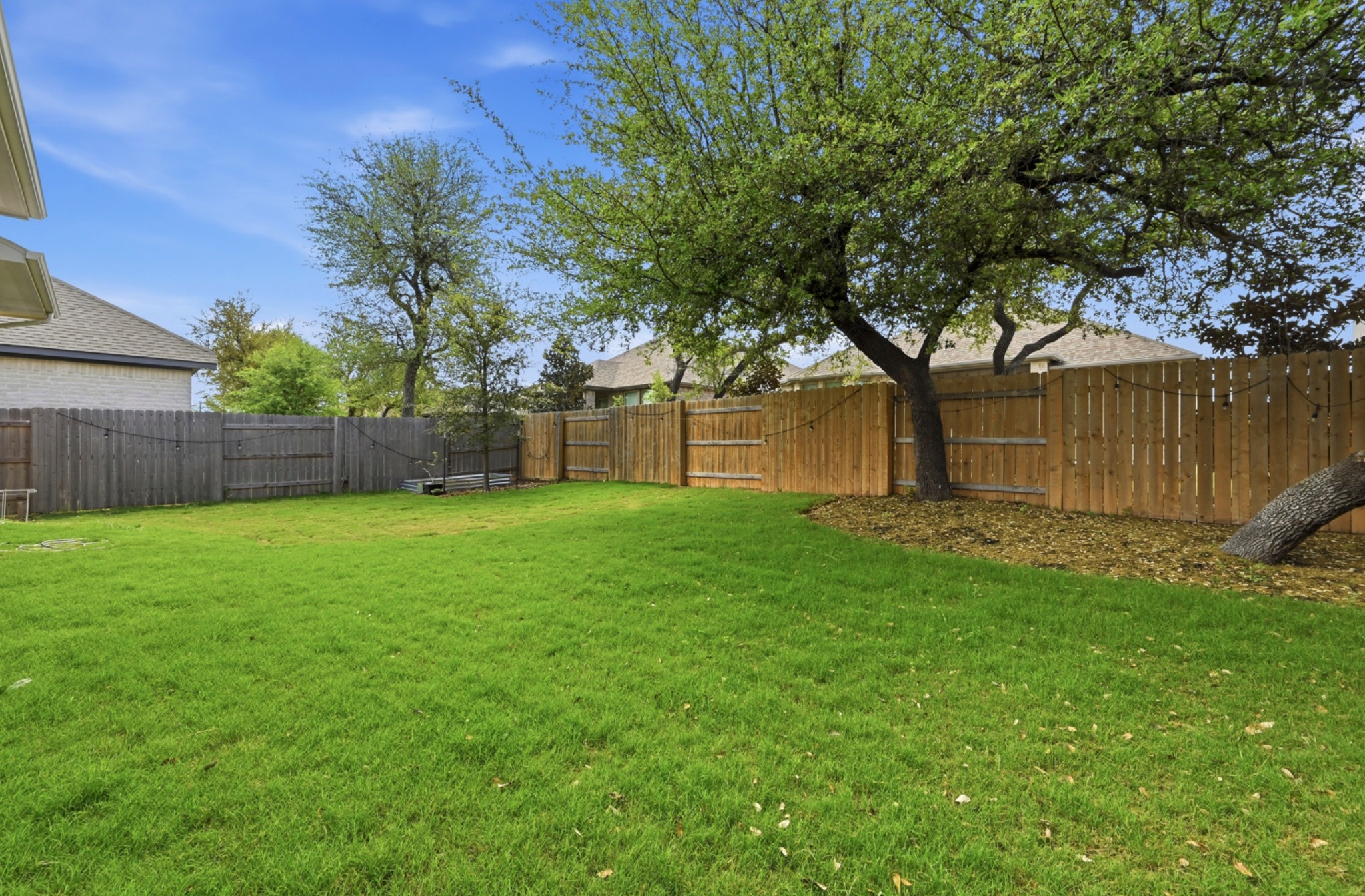 4434 Hannover Way Round Rock, TX 78681 - Photo 32 of 40 a view of a yard with large tree and wooden fence