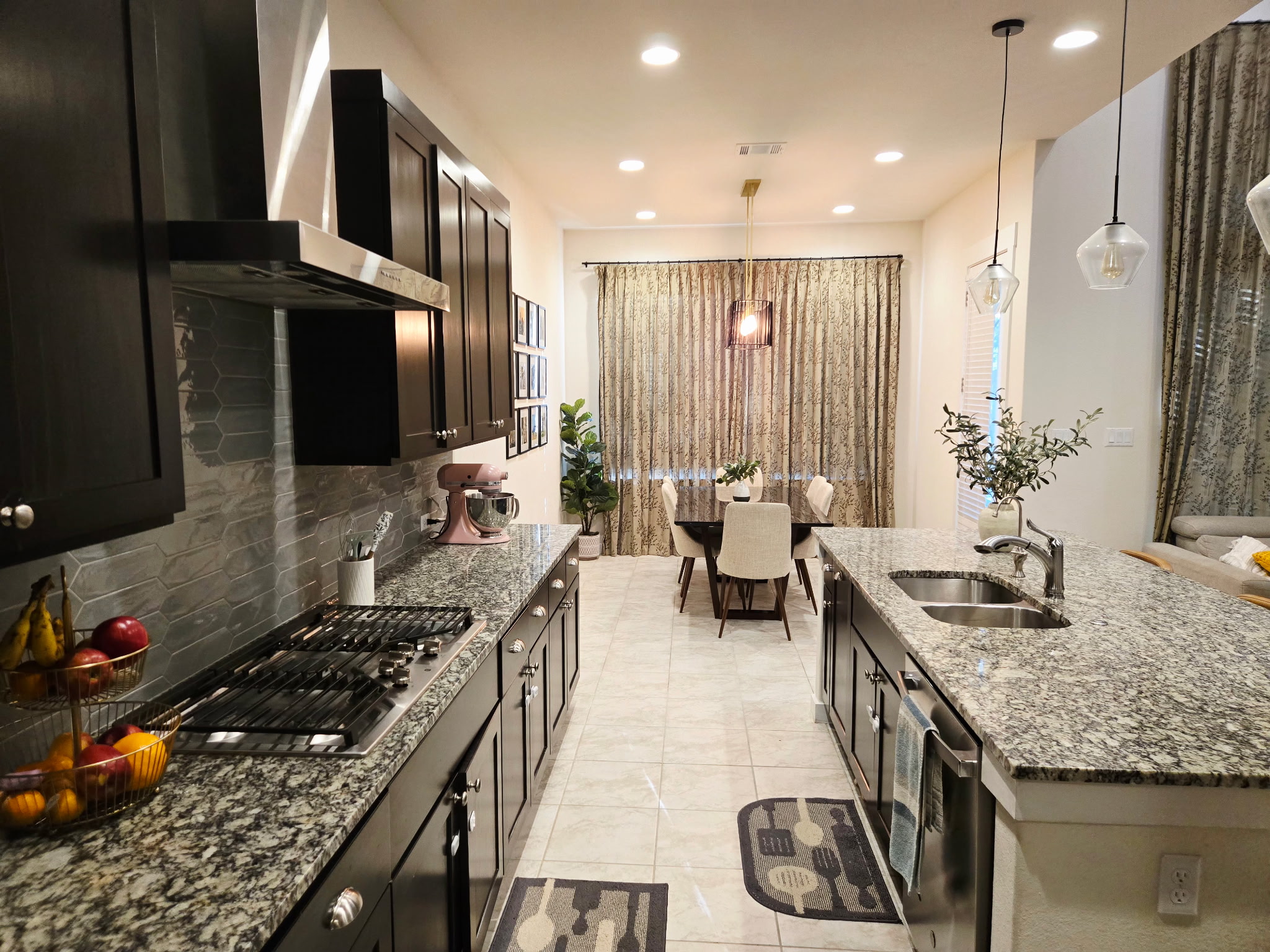 4434 Hannover Way Round Rock, TX 78681 - Photo 4 of 23 Kitchen featuring wall chimney range hood, dark stone counters, decorative light fixtures, and recessed lighting