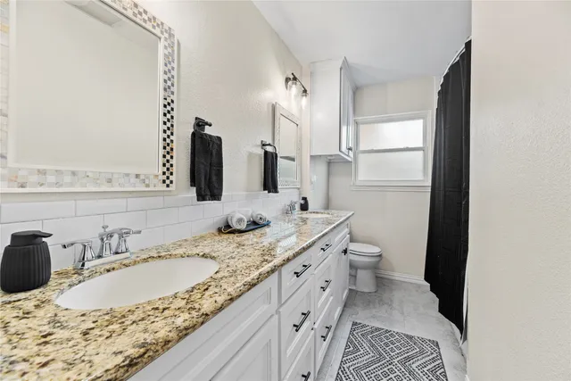 a bathroom with double sink and a mirror
