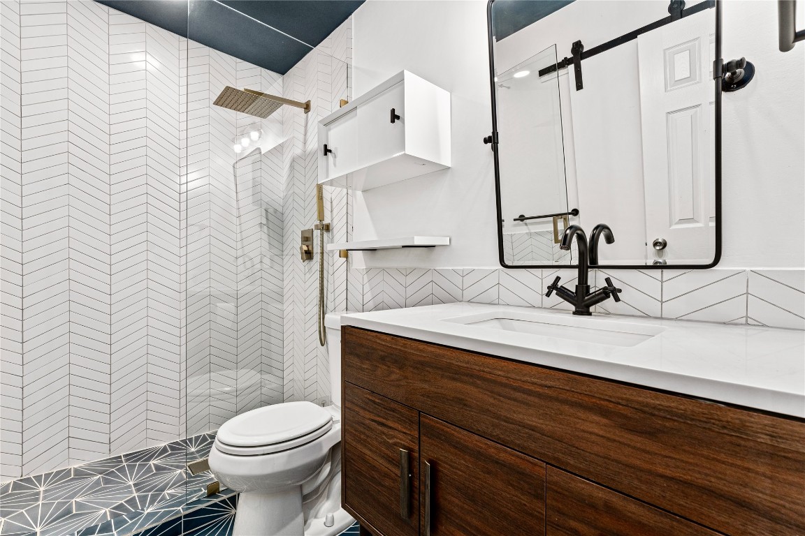 1304 Summit Street, Unit 209 Austin, TX 78741 - Photo 12 of 27 a bathroom with a sink a toilet and shower