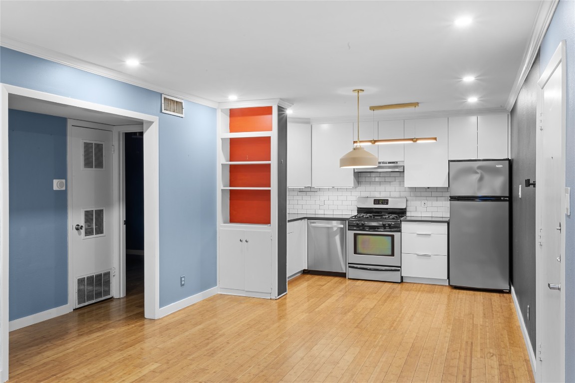 1304 Summit Street, Unit 209 Austin, TX 78741 - Photo 6 of 27 a kitchen with stainless steel appliances a refrigerator and a stove top oven