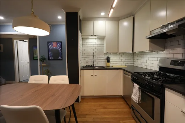 a kitchen with granite countertop a stove a sink a refrigerator and a microwave