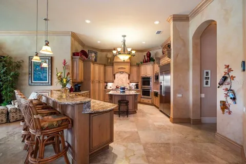 a kitchen with stainless steel appliances granite countertop a sink a stove and refrigerator