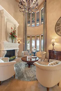 a living room with fireplace furniture and a chandelier
