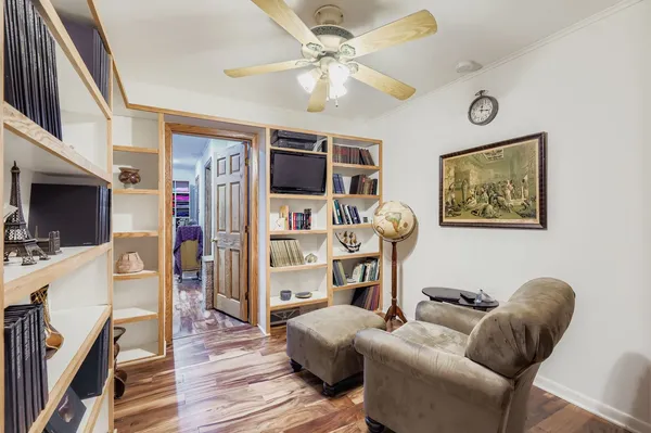a living room with furniture a flat screen tv and a floor to ceiling window