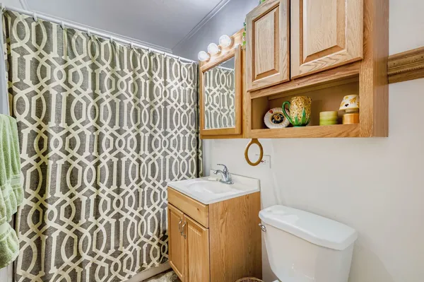 a bathroom with a granite countertop sink and a toilet