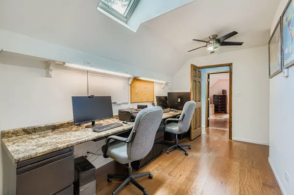 a view of a workspace with furniture and a window