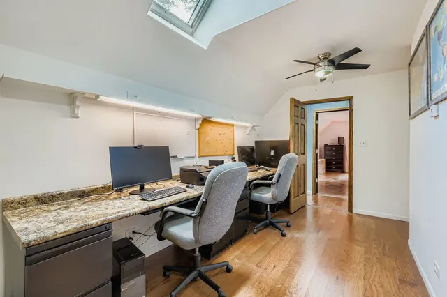 a view of a workspace with furniture and a window