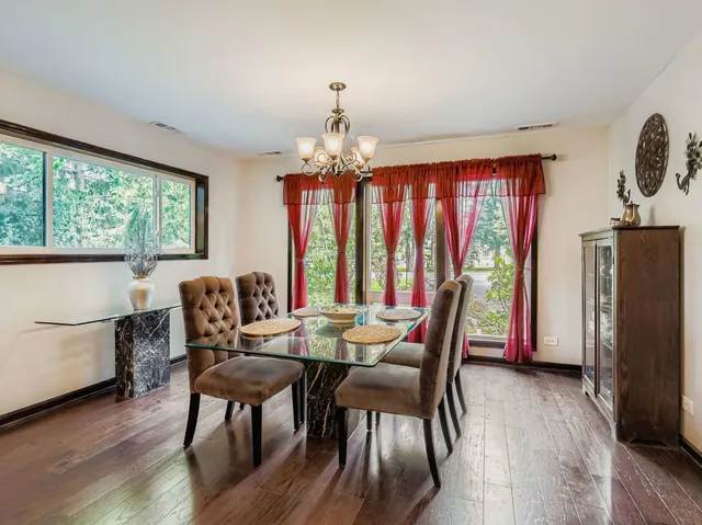 a dining room with furniture window and wooden floor