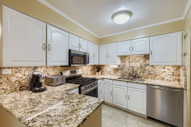 a kitchen with stainless steel appliances granite countertop a sink stove and cabinets
