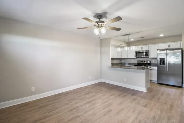 a kitchen with a refrigerator and white cabinets