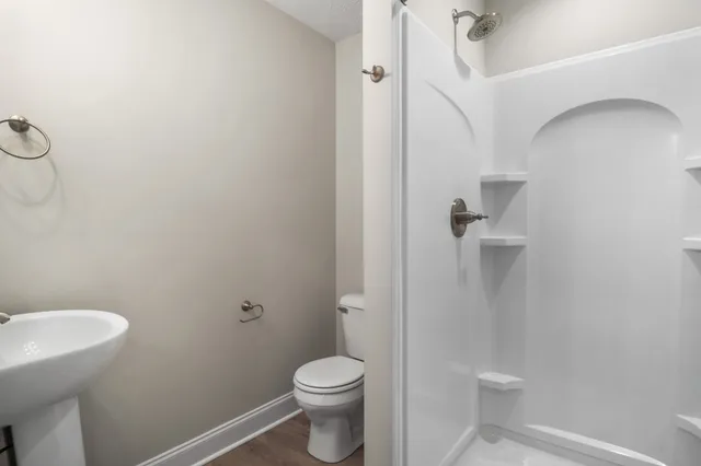a bathroom with a granite countertop toilet and a sink