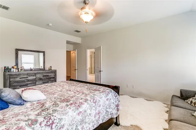 a bedroom with a large bed and a chandelier