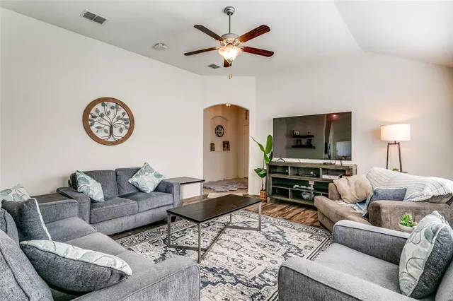 a living room with furniture a flat screen tv and a window