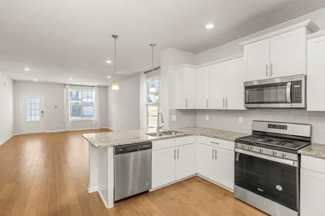 a kitchen with stainless steel appliances granite countertop a stove a sink and a microwave