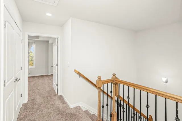 a view of a hallway with wooden floor and staircase