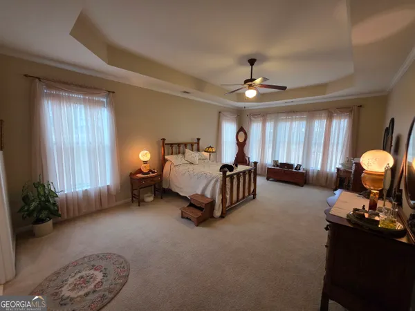 a spacious bedroom with a bed a chandelier and a window
