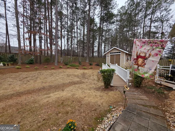a view of a dry yard with wooden fence