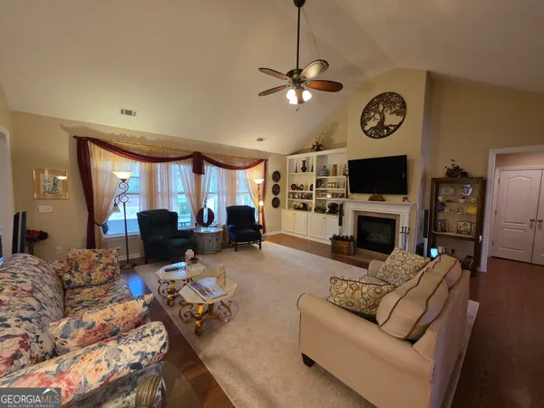 a living room with furniture a fireplace and a flat screen tv
