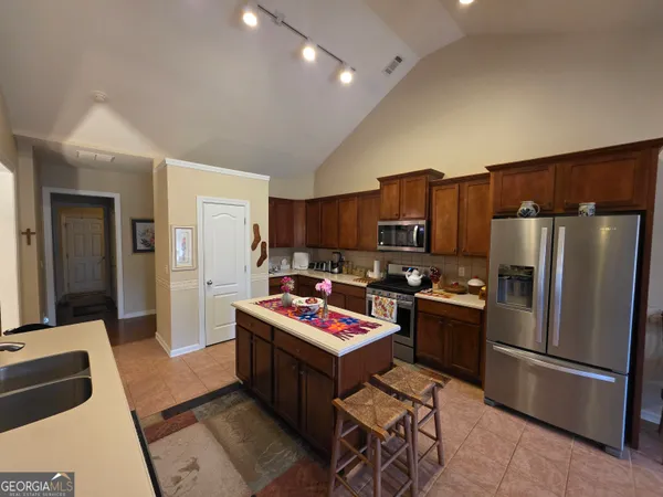 a kitchen with kitchen island a refrigerator stove and microwave