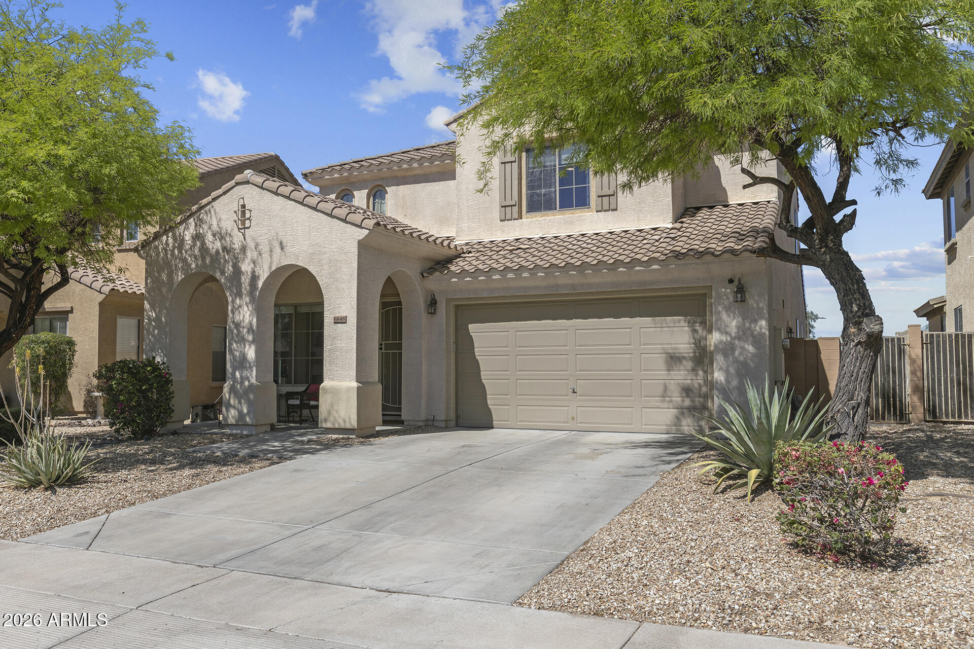 6848 West Ridgeline Road Peoria, AZ 85383 - Photo 2 of 71 a view of a white house with large windows and palm trees