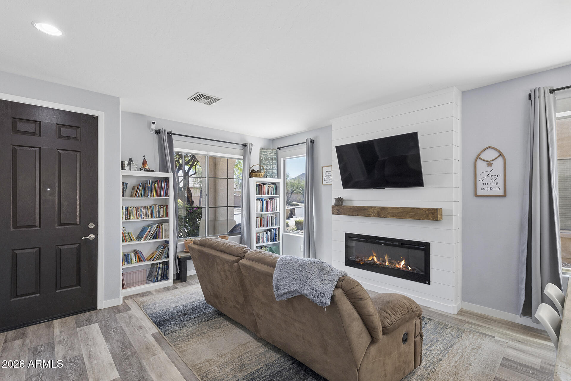 6848 West Ridgeline Road Peoria, AZ 85383 - Photo 8 of 71 a living room with furniture a flat screen tv and a fireplace