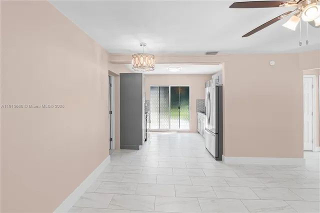 a view of a hallway with wooden floor and chandelier