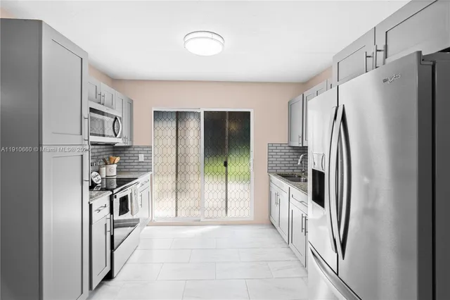 a kitchen with stainless steel appliances granite countertop a refrigerator and a stove top oven