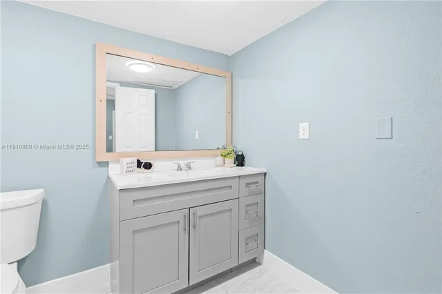 a bathroom with a sink a toilet and mirror