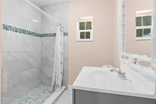 a bathroom with a sink a shower and a mirror