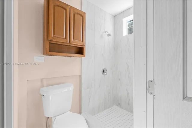 a bathroom with a toilet and a shower