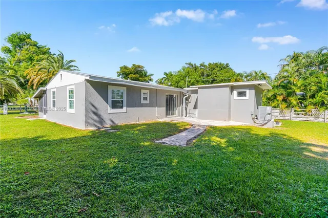 a view of a house with backyard and a tree
