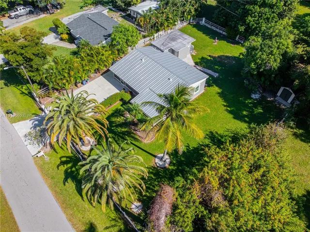 an aerial view of a house with swimming pool and lawn chairs