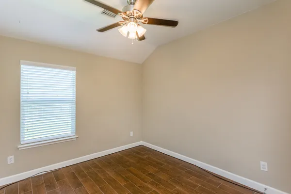an empty room with a window and a fan
