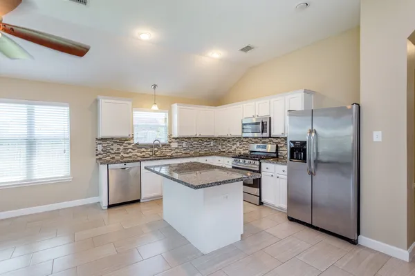 a kitchen with stainless steel appliances granite countertop a sink stove and refrigerator