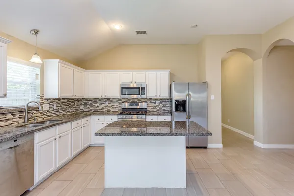 a kitchen with stainless steel appliances granite countertop a sink and stove