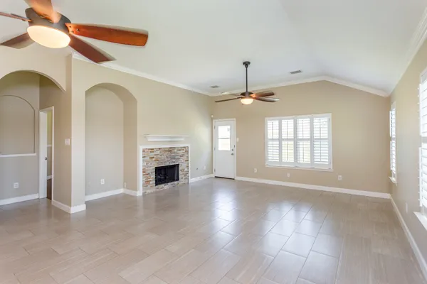 an empty room with windows and fireplace
