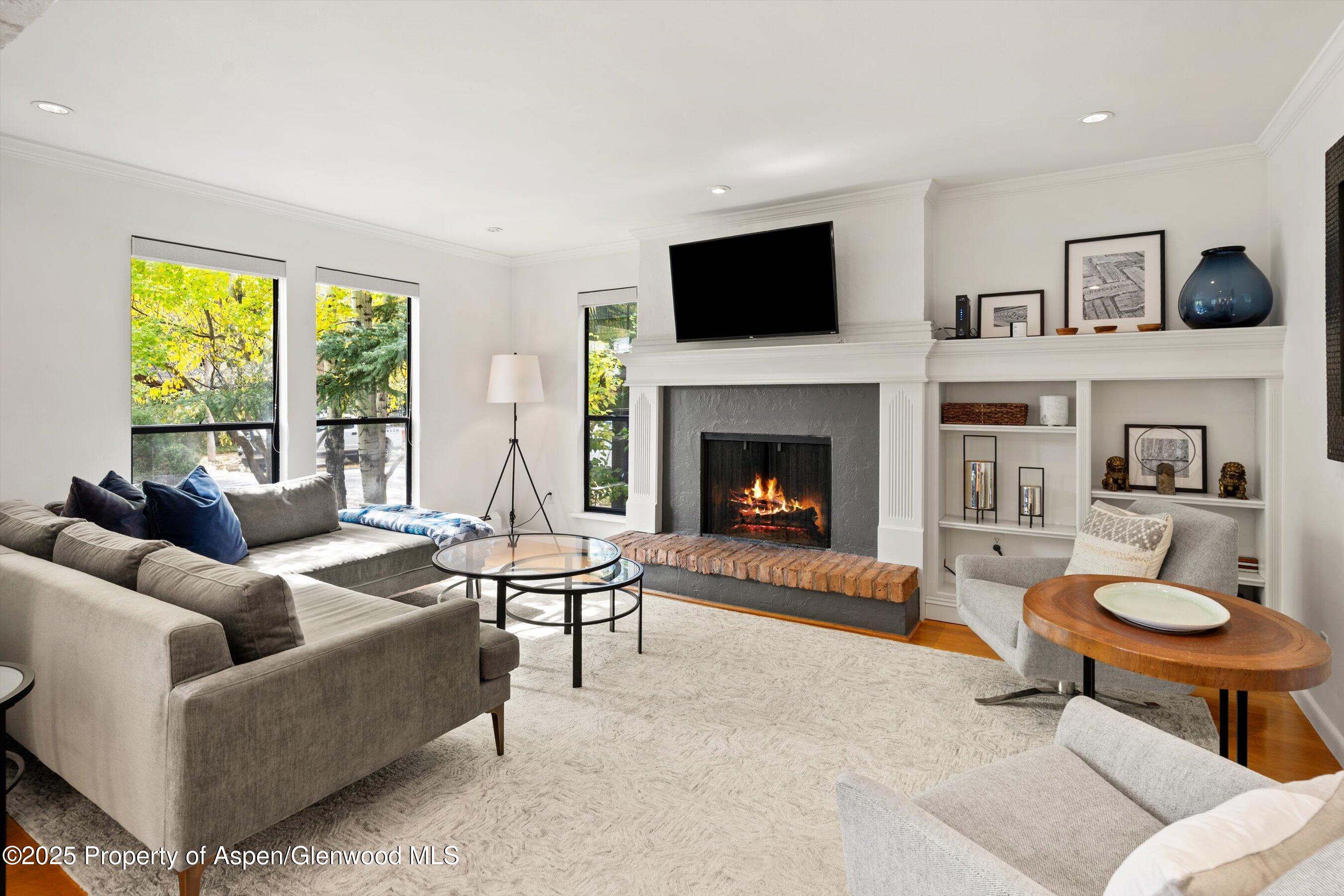 980 East Hyman Avenue, Unit 3 Aspen, CO 81611 - Photo 1 of 26 a living room with furniture a fireplace and a flat screen tv