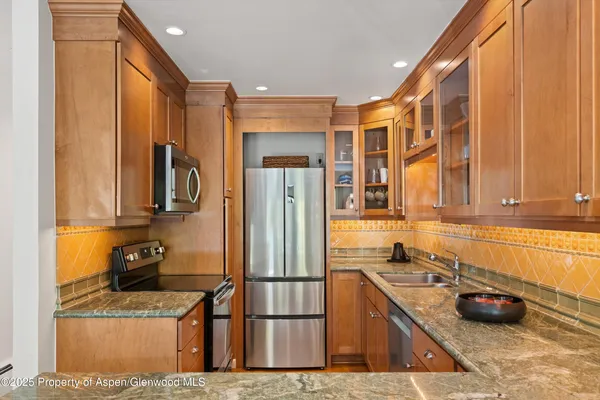 a kitchen with stainless steel appliances granite countertop a refrigerator and a sink
