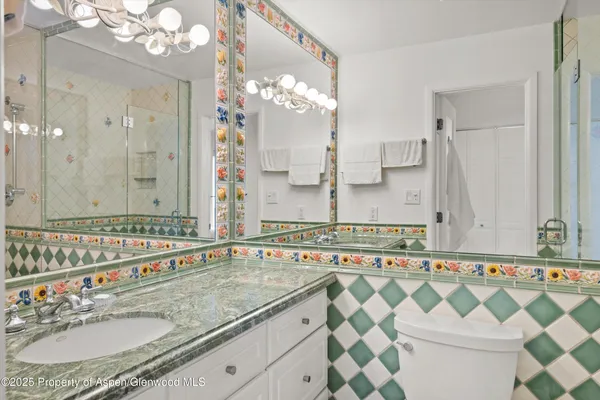 a bathroom with a granite countertop sink a mirror a and a shower
