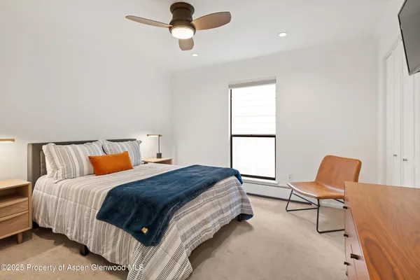 a bedroom with a bed a chair and a window