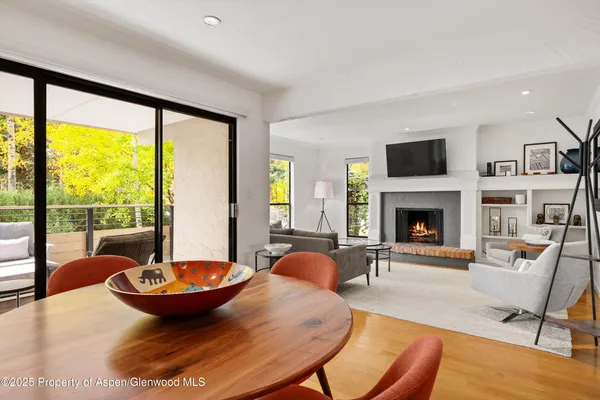 a living room with furniture a fireplace and a floor to ceiling window