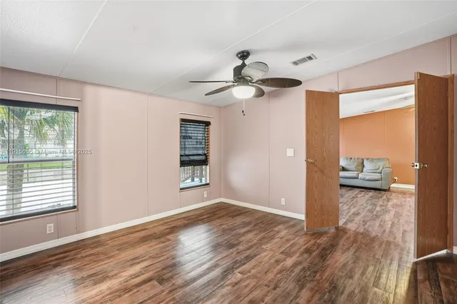 a view of a livingroom with wooden floor and a ceiling fan