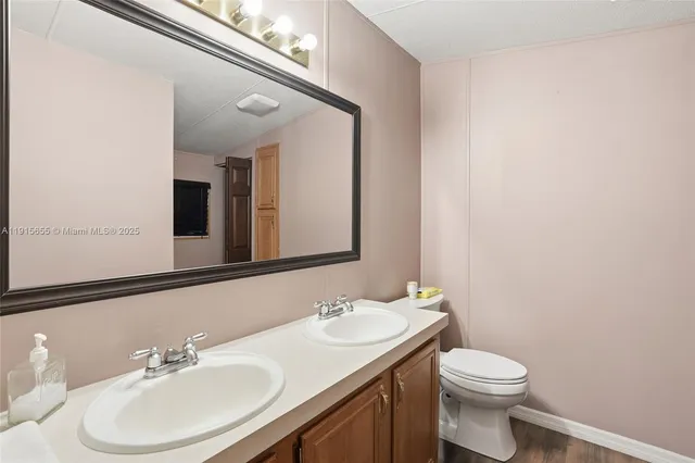 a bathroom with a sink a toilet and mirror